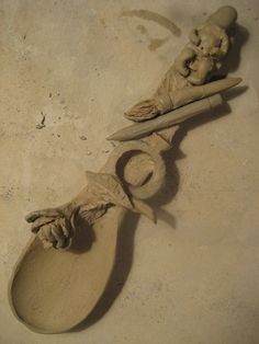 two spoons that have been carved into the shape of people's hands and feet