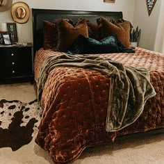 a bedroom with a bed, nightstands and pictures on the wall above it is decorated in brown velvet