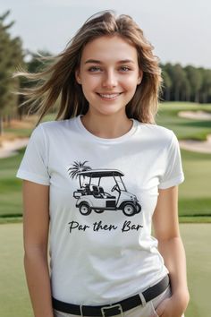 a woman in a white shirt is standing near a golf course and smiling at the camera