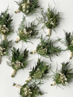 flowers and greenery laid out on a white surface