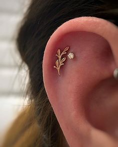 a close up of a person's ear with a tiny flower on the side