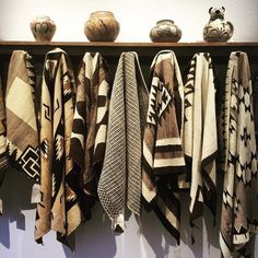 several different types of blankets hanging on a wall