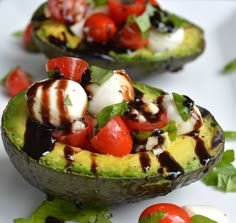 two avocado halves topped with mozzarella, tomatoes and other toppings