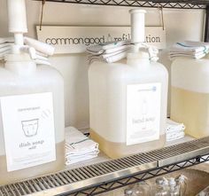 three large jugs of liquid sitting on top of a metal shelf in a store