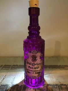 a purple bottle sitting on top of a wooden table