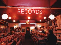 a record shop with records on the wall and lights hanging from the ceiling above it