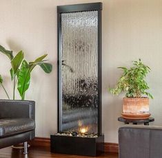 a living room filled with furniture and a tall water fountain in the middle of it