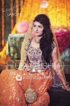 a woman in an orange and gold bridal outfit