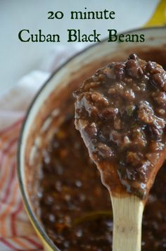 a wooden spoon full of chili and beans in a pot with a cloth on the side