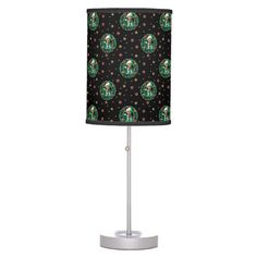 a lamp with a black background and green polka dots on the lampshade is shown