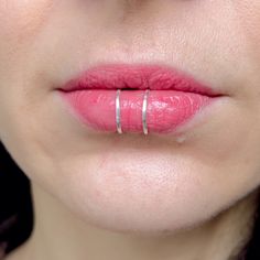 a close up of a woman's lips with ring on her lip