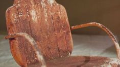 an old wooden chair with rusted paint on it