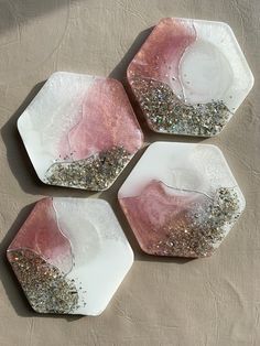 four pink and white hexagonal plates with glitter on them