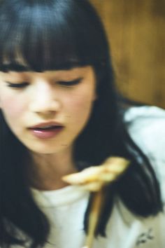 a woman holding a banana in her right hand and looking down at the other side