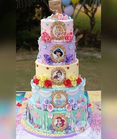 a multi - tiered cake is decorated with princesses and other things on it