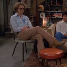 two men sitting in chairs talking to each other on the set of tv show friends