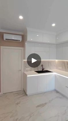 an empty kitchen with white cabinets and marble counter tops, is shown in this image