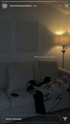 a white couch sitting next to a lamp in a living room