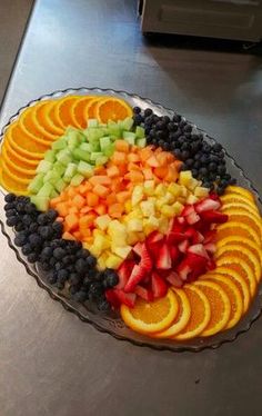 a platter filled with sliced fruit on top of a counter