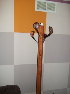 a rack with golf clubs in it next to a wall