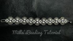 the beaded bracelet is made with pearls and silver beads on black leather, it looks like