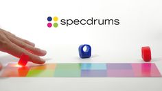 a hand is touching the top of a colorful object that appears to be speccrum's logo