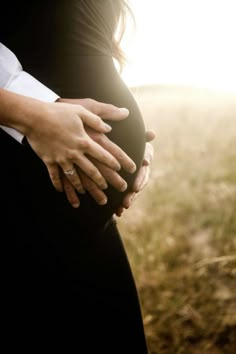 a pregnant woman is holding her husband's belly