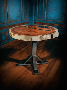 a wooden table sitting on top of a hard wood floor next to a blue wall