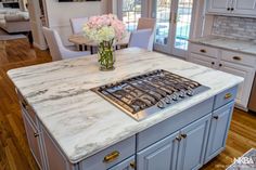 a kitchen with marble counter tops and an island in front of a stove top oven