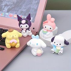 four little figurines sitting on top of a laptop