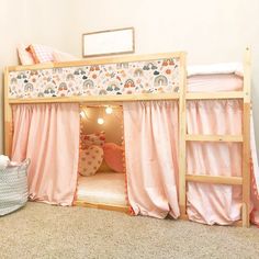 a child's bedroom with pink curtains and a wooden bunk bed