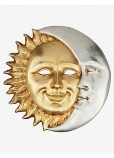 a gold and silver sun and moon brooch with face in the center, against a gray background