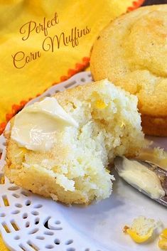 Two corn muffins with a bite out of the front one and butter on the top.