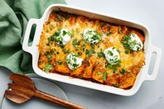 a casserole dish with cheese, sour cream and parsley on the side