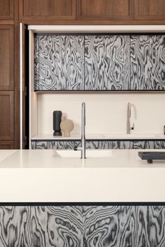 a modern kitchen with wooden cabinets and white counter tops, along with an island style sink