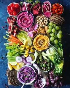 an array of vegetables and dips arranged in the shape of a letter