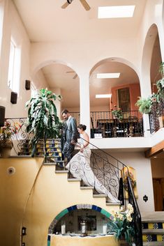 a bride and groom are standing on the stairs