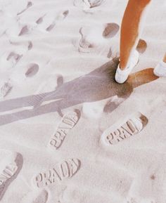 a person standing in the sand with their foot prints