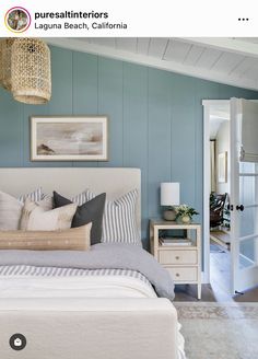 a bedroom with blue walls and white furniture