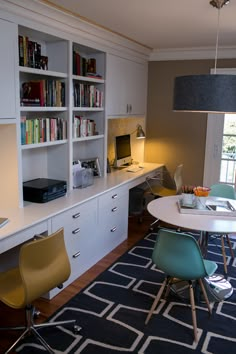 a room with a table, chairs and bookshelves on it's walls