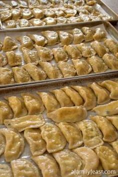 several trays filled with dumplings sitting next to each other