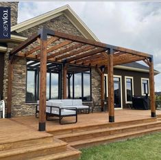 a patio covered in wood and surrounded by grass