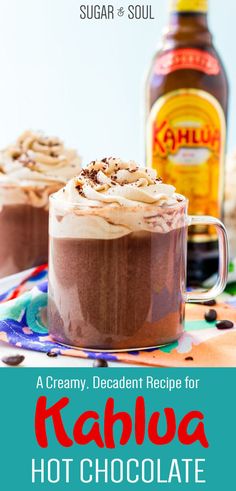 two glasses filled with hot chocolate drink and topped with whipped cream on the top, next to a bottle of booze