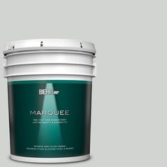 the behr color marquee paint is shown in an open bucket on a gray background