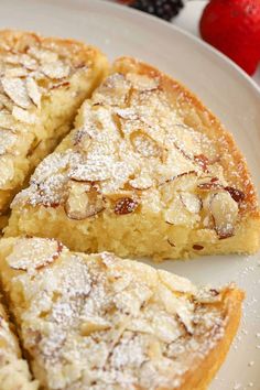 a white plate topped with four pieces of pie covered in powdered sugar next to strawberries