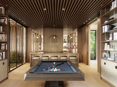 a pool table in the middle of a room with built - in bookshelves