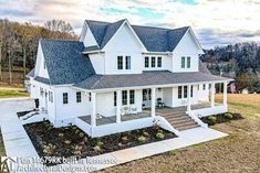 a large white house sitting on top of a lush green field