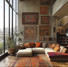 a living room filled with lots of furniture next to large window covered in pictures on the wall