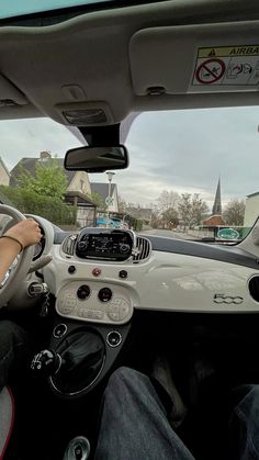 a man driving a small car down a street