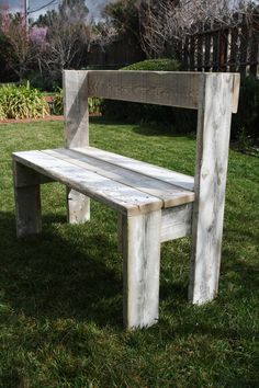 a wooden bench sitting on top of a lush green field